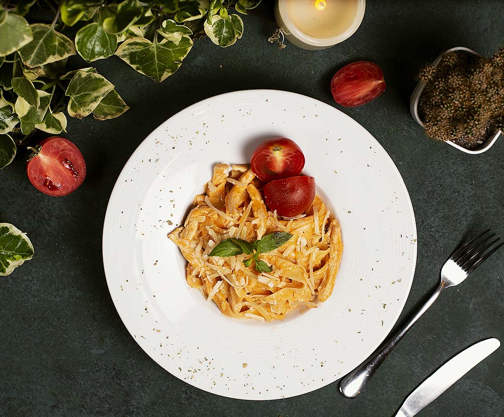 Pasta in tomato sauce with chopped parmesan , tomato and basilic. image